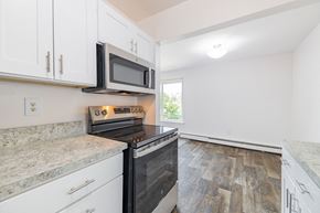 Inkster apartment for rent - A kitchen with a black microwave above a stove top oven.