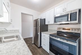 Inkster apartment for rent - A kitchen with a stainless steel refrigerator, oven, and microwave.