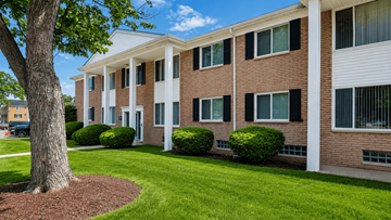 Inkster apartment for rent - A tree is in front of a building with a white roof.