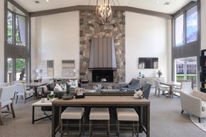 Grand Blanc apartment for rent - A modern dining room with a stone fireplace and a chandelier.
