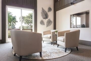 Grand Blanc apartment for rent - A living room with a large chair and a smaller chair with a table in between.