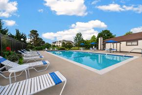 Trenton apartment for rent - A pool with blue and white lounge chairs.