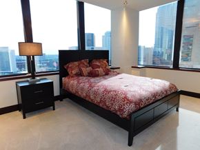 St. Louis apartment for rent - A bedroom with a large bed and a city view.
