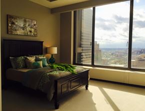 St. Louis townhouse for rent - A bedroom with a large bed and a view of the city.