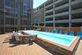 St. Louis townhouse for rent - A pool with a table and chairs is surrounded by a wooden deck.