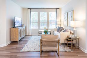 Commerce Township apartment for rent - A living room with a television, a chair, and a table.