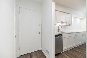 Grand Blanc apartment for rent - A kitchen with white cabinets and a wooden floor.