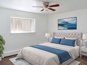 Livonia apartment for rent - A bedroom with a bed, a ceiling fan, and a painting of a mountain.