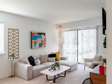 West Bloomfield apartment for rent - A living room with a white couch, a coffee table, and a painting on the wall.
