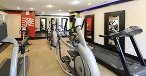 West Bloomfield apartment for rent - a gym with several pieces of exercise equipment and mirrors