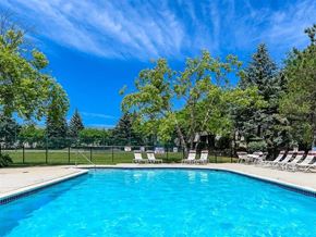 West Bloomfield apartment for rent - a swimming pool with chairs and trees next to it