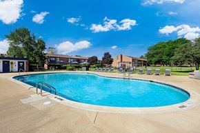 Warren apartment for rent - A large outdoor swimming pool surrounded by a concrete deck and lounge chairs.