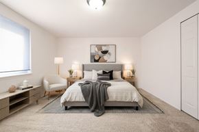 Southfield apartment for rent - A bedroom with a bed, chair, and nightstands.