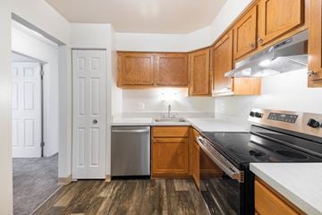 Westland apartment for rent - A kitchen with wooden cabinets and a black stove top oven.