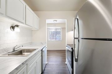 Waterford apartment for rent - A kitchen with white cabinets and a black fridge.