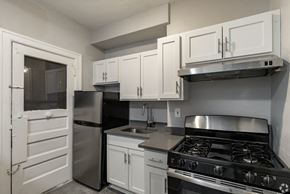 Detroit apartment for rent - a kitchen with white cabinets and stainless steel appliances