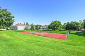 Bloomfield Hills apartment for rent - A tennis court is located in a grassy area.