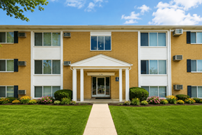 Inkster apartment for rent - A building with a white entrance and a walkway leading to it.