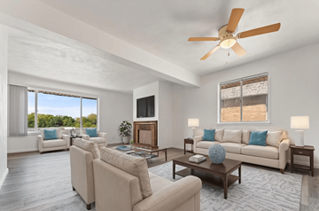 Peoria apartment for rent - A living room with a white ceiling fan and a large window.