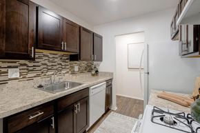 Auburn Hills apartment for rent - A kitchen with a white stove top oven and a white dishwasher.