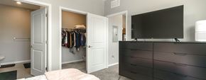 Walled Lake apartment for rent - A black TV is on top of a black dresser in a bedroom.