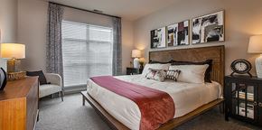 Auburn Hills apartment for rent - A bedroom with a large bed and a wooden headboard.