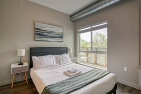 Ann Arbor apartment for rent - A bedroom with a large bed and a painting on the wall.
