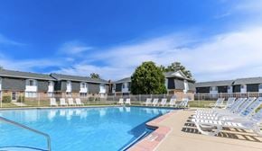 Madison Heights apartment for rent - A swimming pool surrounded by sun loungers and apartment buildings.