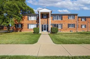 Madison Heights apartment for rent - A brick building with a white entrance and a tree in front.