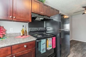 Madison apartment for rent - A black stove and refrigerator in a kitchen with wooden cabinets.