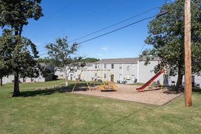 Madison apartment for rent - A playground with a slide and swings in a grassy area.