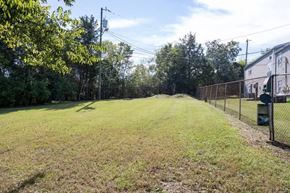 Madison apartment for rent - A grassy field with a fence on one side and trees on the other.