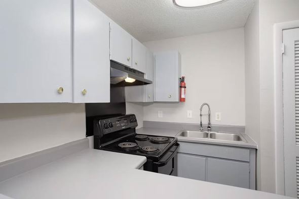 Madison apartment for rent - A kitchen with a black stove top oven and white cabinets.