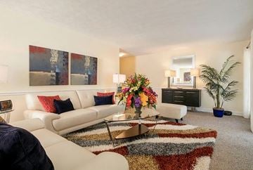 Lithonia apartment for rent - A living room with a white couch, a coffee table, and a large painting on the wall.