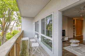Ann Arbor apartment for rent - A balcony with a table and chairs overlooking a tree.