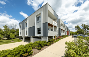 Ann Arbor apartment for rent - A modern building with a grey facade and a parking lot in front.