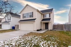 Saratoga Springs apartment for rent - a beige house with a yard with snow on the ground