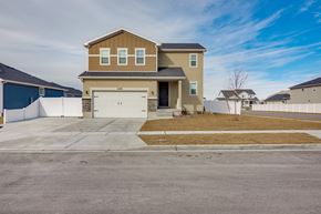 Stansbury Park apartment for rent - A two-story house with a garage is situated in a residential area.