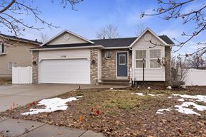 Layton apartment for rent - A house with a grey garage door and a black front door.