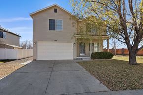 Spanish Fork apartment for rent - a tan house with a white garage door and a driveway