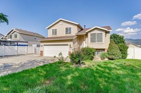 Woods Cross apartment for rent - A house with a white garage door is surrounded by a white fence.