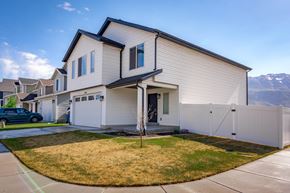 American Fork apartment for rent - A white house with a black roof and a car parked in front.