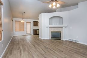 Herriman apartment for rent - an empty living room with a fireplace and a ceiling fan