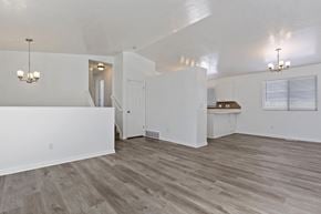 Syracuse apartment for rent - an empty living room and kitchen with white walls and wood flooring
