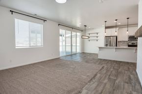 Stansbury Park apartment for rent - A spacious living room with a sliding glass door leading to a balcony.
