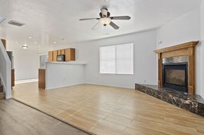 Spanish Fork apartment for rent - an empty living room with a fireplace and a ceiling fan