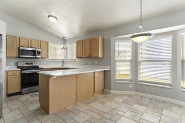 Layton apartment for rent - A kitchen with wooden cabinets and a tiled floor.