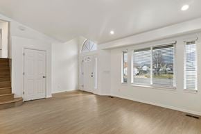 Kaysville apartment for rent - A spacious room with wooden floors and white walls.