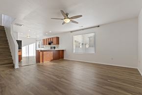 Spanish Fork apartment for rent - an empty living room with a ceiling fan and a kitchen