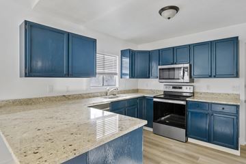 Lehi apartment for rent - A kitchen with blue cabinets and a granite countertop.